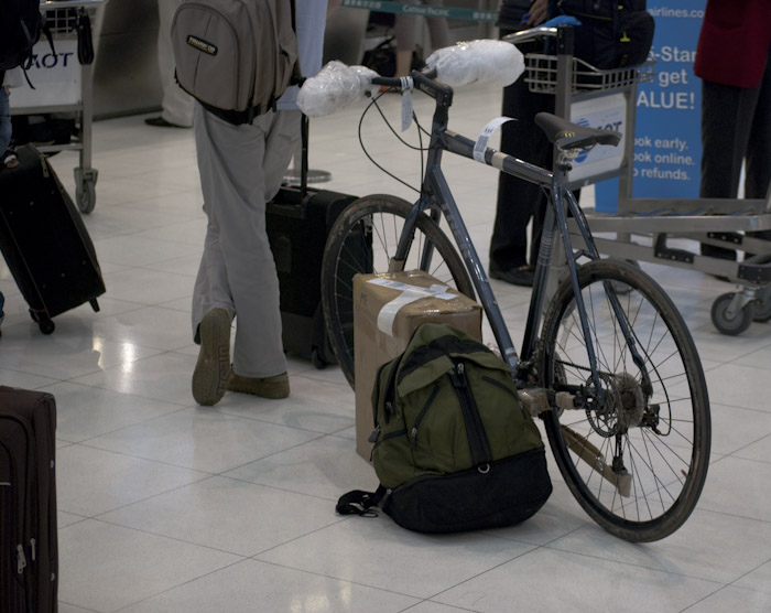 bicycle, box and backpack in check-in line